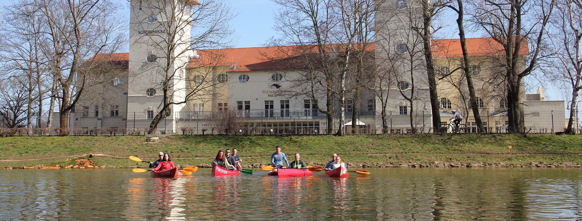 Eine Gruppe Menschen fährt mit dem Kanu auf den Leipziger Kanälen.
